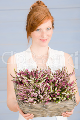 Summer redhead woman hold basket with flowers