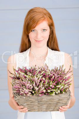 Summer redhead woman hold basket with flowers