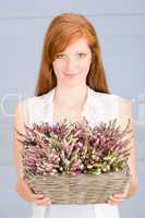 Summer redhead woman hold basket with flowers