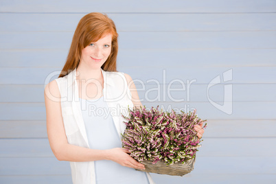 Summer redhead woman hold basket with flowers