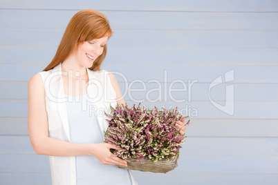 Summer redhead woman hold basket with flowers