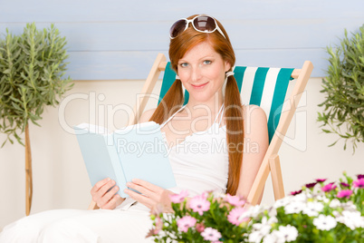 Summer terrace red hair woman relax in deckchair