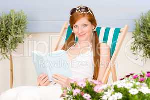 Summer terrace red hair woman relax in deckchair
