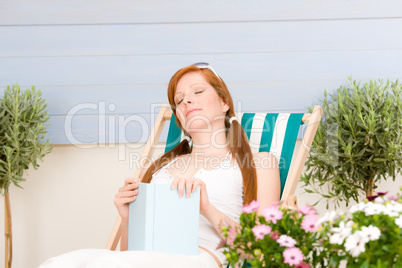 Summer terrace red hair woman relax in deckchair