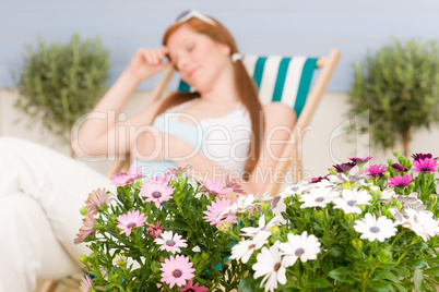 Summer terrace red hair woman relax in deckchair