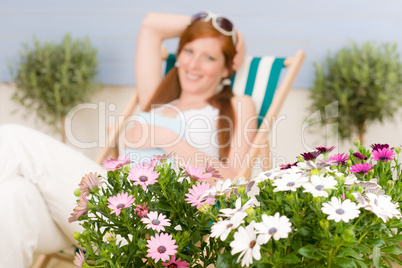 Summer terrace red hair woman relax in deckchair