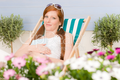 Summer terrace red hair woman relax in deckchair