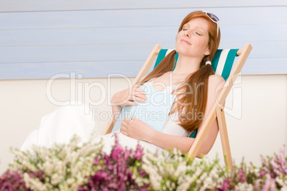 Summer terrace red hair woman relax in deckchair