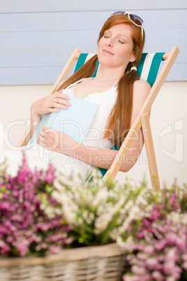 Summer terrace red hair woman relax in deckchair