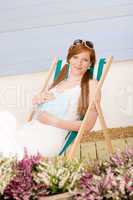 Summer terrace red hair woman relax in deckchair