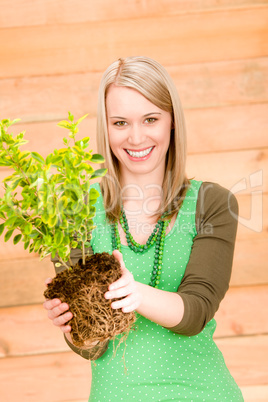 Portrait happy woman hold plant spring gardening