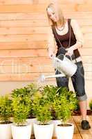 Gardening woman watering plant spring terrace