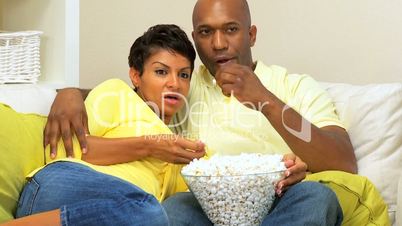 Ethnic Couple Watching Scary Movie with Popcorn