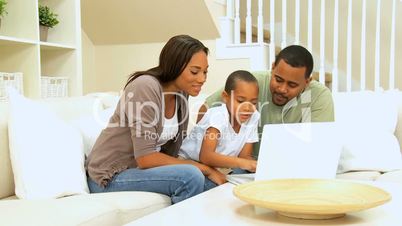 Parents Watching Son Using Laptop Computer