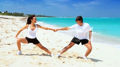 Young Couple in Sportswear Exercising on Beach