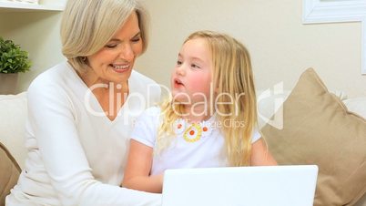 Proud Grandma with Grandchild Playing on Laptop