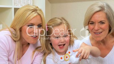 Little Girl Playing on Games Console with Family in Close-up