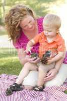Mother and Son Talk about Pine Cones in Park