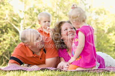 Happy Young Family with Cute Twins in Park