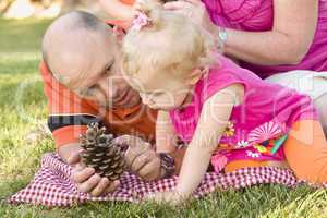 Father and Daughter Talk about Pine Cone in Park