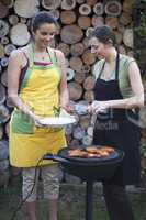 Zwei Frauen bei Gartenparty mit Grillen