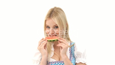 Frau im Dirndl isst Wassermelone