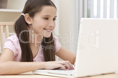 Girl Child Using Laptop Computer At Home