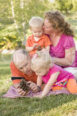 Young Family Talking about Pine Cones in Park