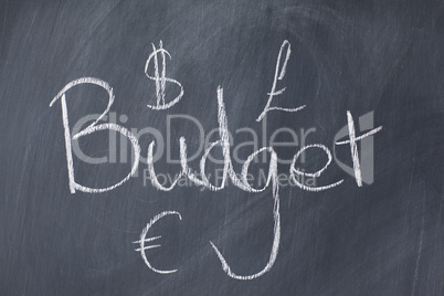 Word "budget" and currencies on a blackboard