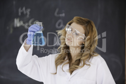 Female scientist looking at a flask