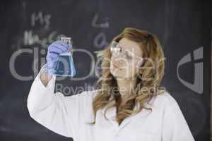 Female scientist looking at a flask