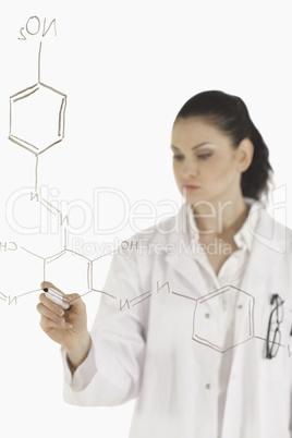 Dark-haired scientist writing a formula on a white board