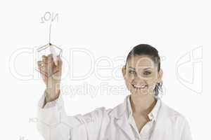 Dark-haired scientist writing a formula on a white board