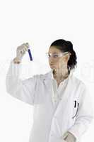 Dark-haired scientist looking at a test tube