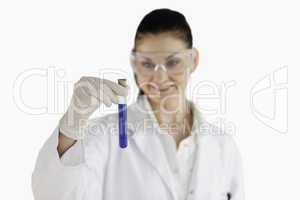 Smiling female scientist looking at a blue test tube