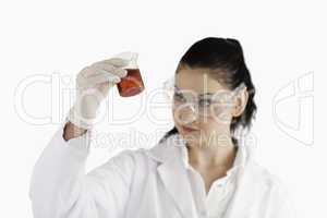 Isolated scientist looking at a red beaker