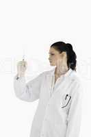 Dark-haired doctor looking at a syringe