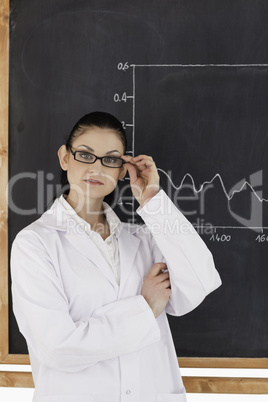 Female scientist standing near the blackboard