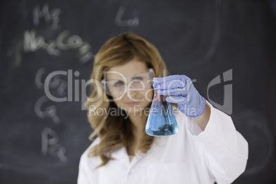 Cute female scientist carrying out an experiment