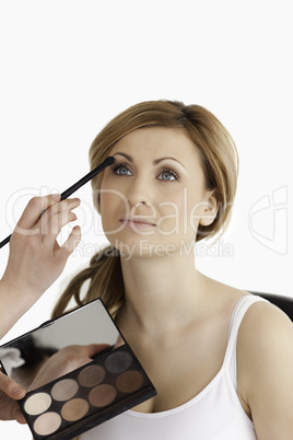 Make-up artist applying make up to a young female