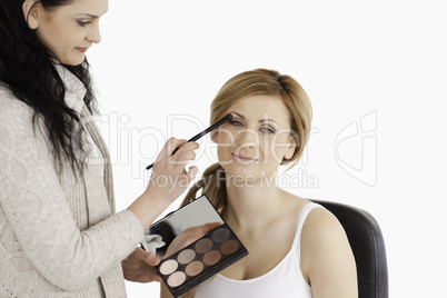 Attractive woman having her make up done by a make up artist