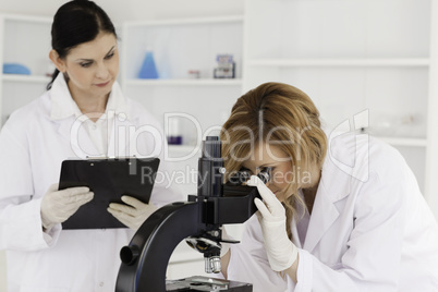 Blond-haired scientist and her assistant conducting an experimen