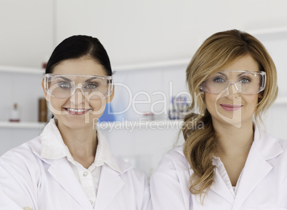 Two female scientists with safety glasses looking at the camera