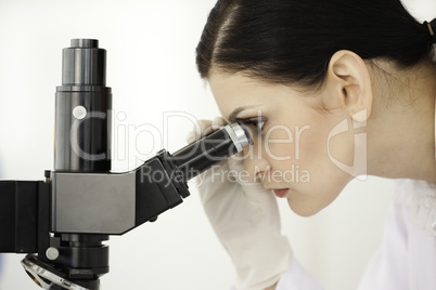 Scientist looking through a microscope in a lab