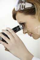 Scientist carrying out an experiment looking through a microscop