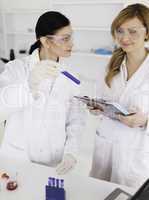 Two scientists observing a blue test tube