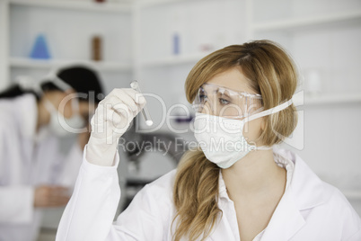 Blond-haired scientist observing a test tube