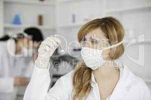 Blond-haired scientist observing a test tube