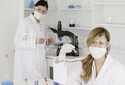 Dark-haired and blond-haired scientists carrying out an experime