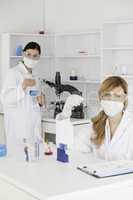 Blond-haired and dark-haired scientists conducting an experiment